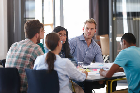 The deadline is looming. a group of designers in an office meeting.の写真素材