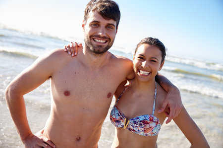 Confident in our relationship. Portrait shot of a happy young couple posing affectionately at the beach.の写真素材