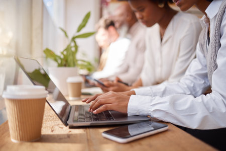 Business people, coworking space and hands on laptop, online and communication technology in office. Advertising, marketing or internet, search or feedback by women and men writing review or proposalの写真素材