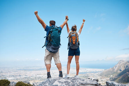 Success, hiking and couple holding hands on mountain for celebration, motivation and freedom on travel in Costa Rica. Back of happy, excited and trekking man and woman celebrate adventure on a cliffの写真素材