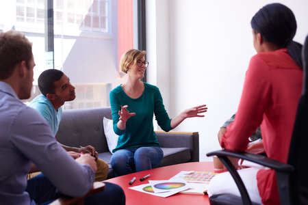 An informal business meeting. A group of informal businesspeople in a meeting.の写真素材