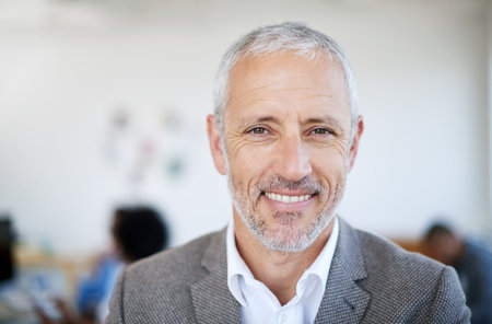 The smile of success. Portrait of a mature businessman standing in an office.
