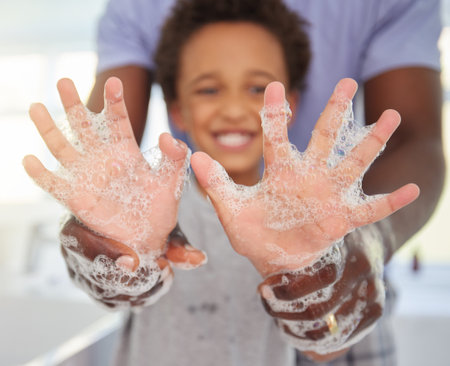 Black family, washing hands and soap foam with a father and child in a bathroom with a smile. Blurred background, papa helping and hygiene support of a kid with dad together with happiness and careの写真素材