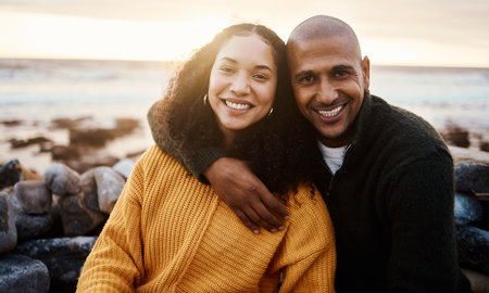 Romantic, happy and portrait of a couple at the beach for a date, bonding or sunset in Bali. Love, hug and young man and woman smiling while relaxing at the ocean for vacation or an anniversaryの写真素材