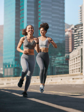 Fitness, woman and friends running in the city for cardio exercise, training or workout together in the outdoors. Happy active women enjoying a run for a healthy balanced lifestyle in Cape Townの写真素材