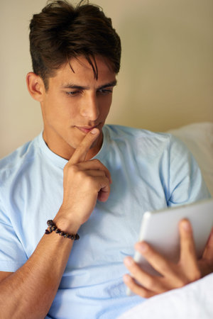 Its so unpredictable. a handsome young man using his digital tablet at home.