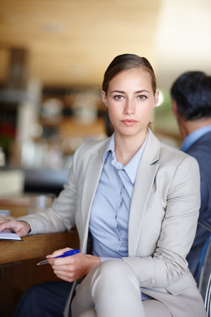 Not just a pretty face. A cropped shot of a serious young businesswoman sitting at work.の写真素材