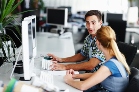 The dynamic duo. Two colleagues working on a computer together.の写真素材