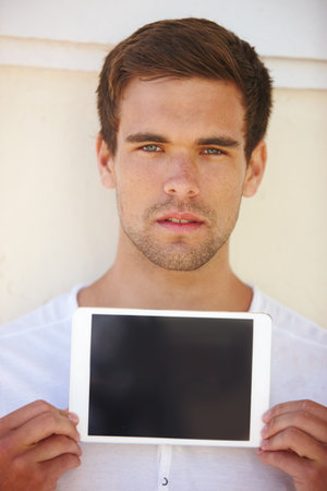 Techno savvy. a handsome young man holding his digital tablet.の写真素材