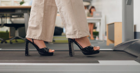Feet, walking and treadmill with a business woman in the breakroom of her office for exercise or mobility. Fitness, health or corporate with a female employee in heels staying active in the workplaceの写真素材