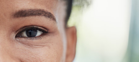 Eye focus, vision zoom and mockup of a black woman outdoor with blurred background. Eyes closeup, portrait and health care for optometry and eyesight check with a young African female with mock upの写真素材