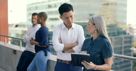 Business people diversity, tablet or office balcony in digital marketing research, strategy planning or calendar management. Mature ceo, talking manager or internship training schedule on technologyの写真素材