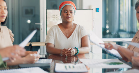 Headache, meeting and business black woman pain, stress or anxiety, thinking of documents review. Burnout, fatigue or frustrated worker or employee in busy office conference, paperwork and team handsの写真素材