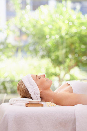 Totally relaxed after her massage. a woman in a day spa relaxing on a massage table.の写真素材
