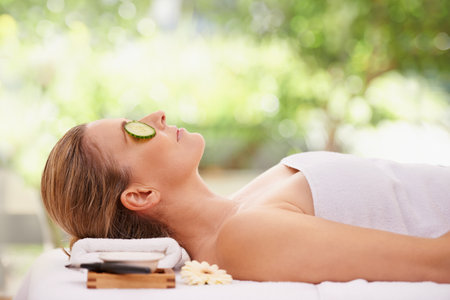 She opted for the full treatment. a woman in a day spa relaxing on a massage table.の写真素材