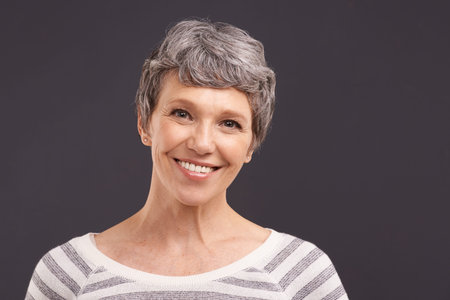 Forever beautiful. Studio portrait of a happy elderly woman against a gray background.