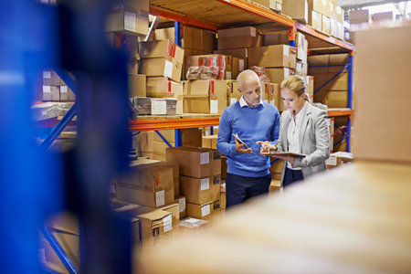 We always double check orders. a man and woman inspecting inventory in a large distribution...