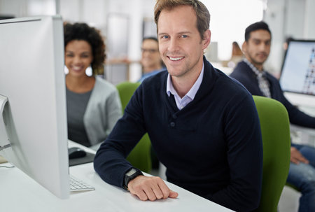 Hes confident about his team. Cropped portrait of smiling office coworkers at their desks.