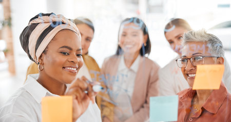 Planning, strategy or happy black woman writing a marketing or advertising plan for business ideas. Sticky notes, meeting or creative people working on global startup project target or team goalsの写真素材