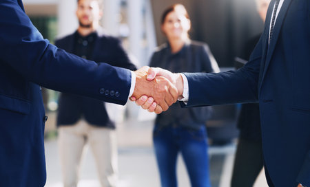 Congratulations, lets do this. Cropped shot of two unrecognizable businesspeople shaking hands while in the office during the day.の写真素材