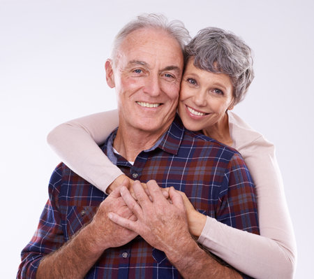 Shes always got my back. Studio portrait of an affectionate elderly couple against a white background.の写真素材