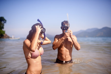 Theyre going under. a happy young couple in snorkeling gear at the beach.の写真素材