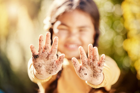 Dirt soil hands, girl child and gardening mockup with blurred background with smile, happiness and...