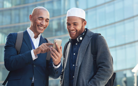 Business, smartphone and men in city, conversation and online reading to share ideas. Corporate, Islamic male and friends in town, cellphone and discussion for social media, typing and connectionの写真素材