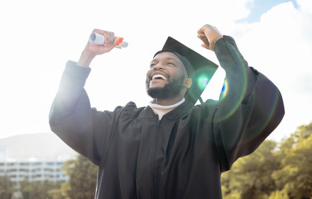Graduation, fist and black man celebrate success, achievement and college target. Happy graduate, education celebration and excited for university goals, learning award and student motivation of hopeの写真素材