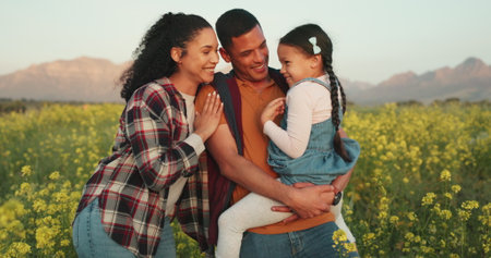 Family, farm and a couple with child in field of flowers, happy, sustainable and together. Man, woman and kid, sustainability countryside farmer in nature farming with trust and support for future.の写真素材