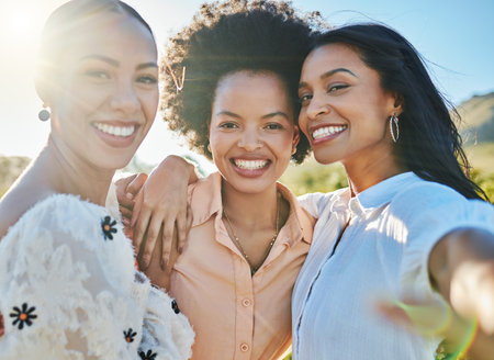 Friends, selfie and women smile in portrait with hug, freedom together outdoor and nature, happy with lens flare. Travel, adventure and happiness in picture, female friendship and fun summer holiday.の写真素材