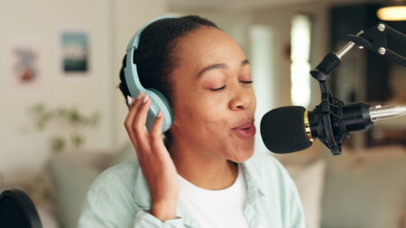 Podcast, radio and report with a woman recording or live streaming content with a microphone and headphones. Influencer, reporter or journalist talking on air and broadcasting the news onlineの写真素材