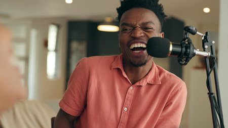Happy black man interview online podcast, radio host laughing talking and speaking on microphone. Influencer live streaming audio production, live streaming broadcast at home and content creationの写真素材