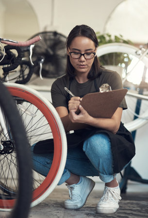 Repairs are done on this one. Full length shot of an attractive young woman crouching in her bicycle...