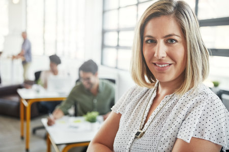 Woman, office portrait and happy with arms crossed with business people, success or vision at web design company. Creative woman, motivation and leader for career goals, mission and smile in New Yorkの写真素材