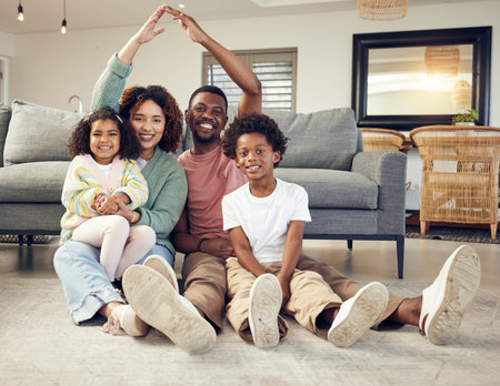 Family, portrait and protection, love and insurance for security with parents and children. Hands together, roof and happy people in living room, unity and safety for life and home cover with smileの写真素材