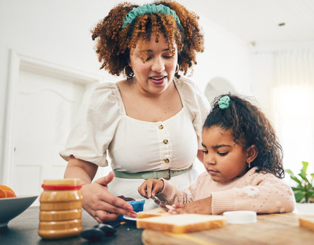 Love, breakfast food and black family child, mother or people eating meal, bonding and prepare ingredients. Morning cooking, kitchen counter or hungry mom with young kid making peanut butter sandwichの写真素材