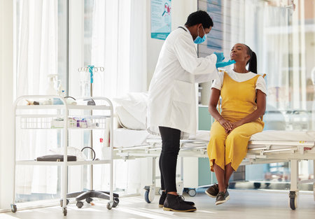Covid, healthcare and test with a black woman patient talking to a doctor for consulting during a checkup. Compliance, medical and insurance with a female in a hospital testing for the corona virusの写真素材