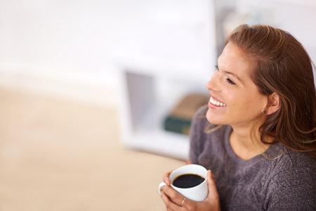 Enjoying the comforts of home. a young woman having coffee at home.の写真素材