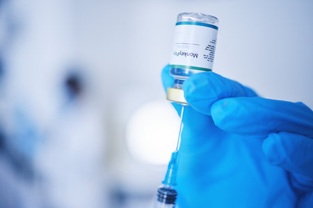 Injection vial, doctor and monkeypox vaccine of safety, healthcare medicine or pharmaceutical laboratory test. Closeup needle, hands and liquid bottle of virus risk, wellness or medical science drugsの写真素材