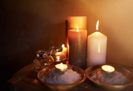 Creating tranquility. An arrangement of scented candles, salts and oils at a spa.の写真素材