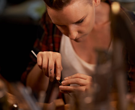 Shes in the crafting zone. A young woman working with tools at a wooden work station.