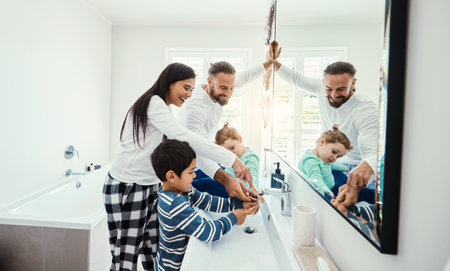 Family, washing hands and bathroom with a mom, father and children with hygiene care in morning. Mother, kids and dad together with love, support and youth in a home doing self care at a sinkの写真素材