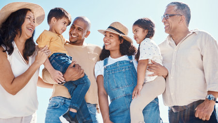 Children, beach and summer with a black family together outdoor on the sand by the ocean or sea for holiday. Kids, love or nature with siblings, parents and grandparents bonding outside on the coastの写真素材