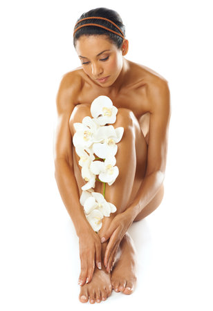 Body, skincare and woman with flowers in studio for natural beauty, product or cosmetics promotion in mockup. Legs, manicure and pedicure of model with floral skin care, dermatology and luxury spaの写真素材