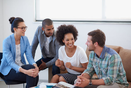 Theyre making great progress. a diverse group of designers having a meeting around a coffee table.
