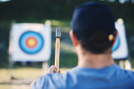 Sports, bullseye and man with axe for target on range for training, exercise and hunting competition. Extreme sport, fitness and male archer aim with tomahawk weapon for practice, games and adventureの写真素材