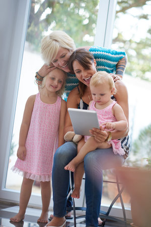 Shes a fast little learner. a lesbian couple showing their daughters how to use a digital tablet.