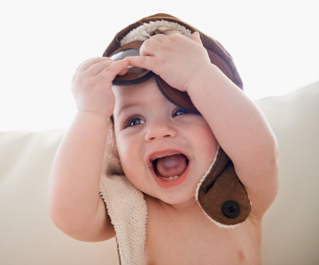 Having so much fun. a baby boy wearing a hat and being playful.の写真素材