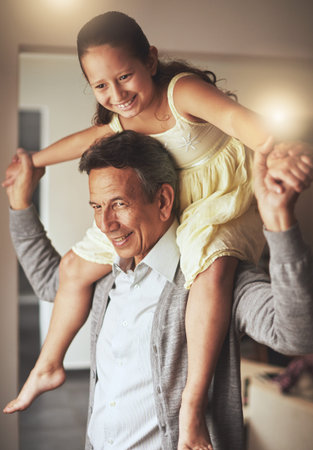 Special moments with his granddaughter. a grandfather giving his granddaughter a piggyback ride at...